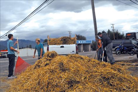 Noah Cheff, Ashtin Courville, Cori Normandeau, Veyanna Curley, and Principal Curt Schutzmann shovel up hay that was left scattered after young vandals caused $8,500 worth of damage at Ronan Power Products.