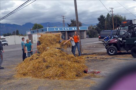 Noah Cheff, Ashtin Courville, Cori Normandeau, Veyanna Curley, and Principal Curt Schutzmann shovel up hay that was left scattered after young vandals caused $8,500 worth of damage at Ronan Power Products.