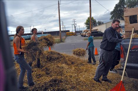 Noah Cheff, Ashtin Courville, Cori Normandeau, Veyanna Curley, and Principal Curt Schutzmann shovel up hay that was left scattered after young vandals caused $8,500 worth of damage at Ronan Power Products.