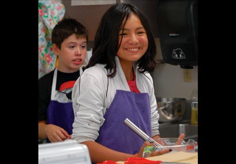 Kyle Finley, front, and Jeremy Bockus stir the ice cream mixture. 