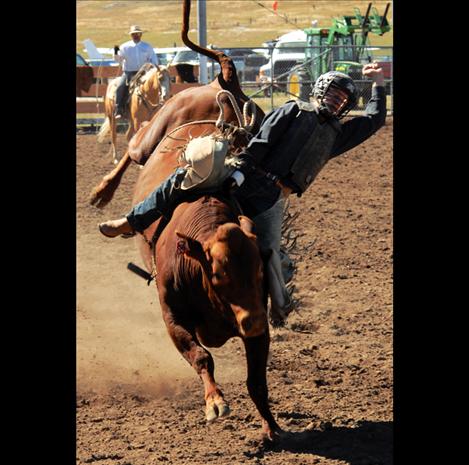 Tristan O’Neal rides a red bull at the Polson High School rodeo.