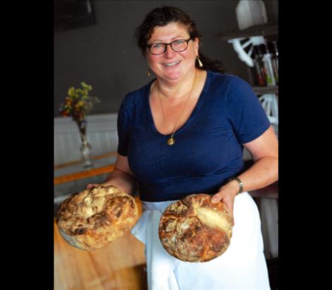 Holding loaves of her homemade rustic Italian bread, Mary Frances Caselli heads for the display case.