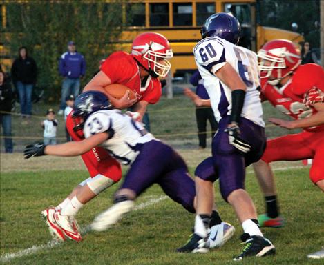 Warrior quarterback Riley Rogers faces tough defense from Viking Bridger Smith.