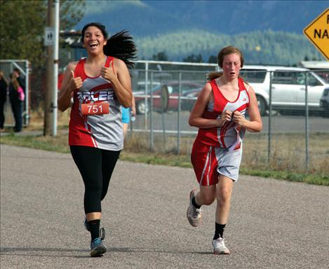 Scarlet Naomi Plant gives an enthusiastic thumbs up while pacing teammate Alice North at Hatchery Challenge Invite