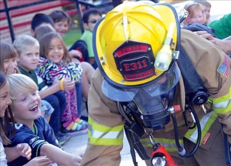 Second grade students at Linderman Elementary School try to attract Polson Firefighter Tanner Hayes’ attention.