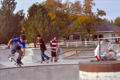 Children skate next to an overflowing garbage can at the park in St. Ignatius. Upkeep of the facility has Councilman Roger Lemon  concerned. 