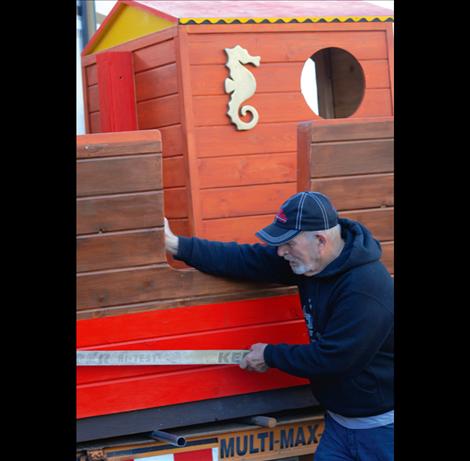 Blackhawk builder Doug Richards helps push the playhouse into its new home.