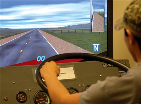 SKC student Bartholomew Owen Chief “drives” the simulator at the Highway Construction Training Programs opening.