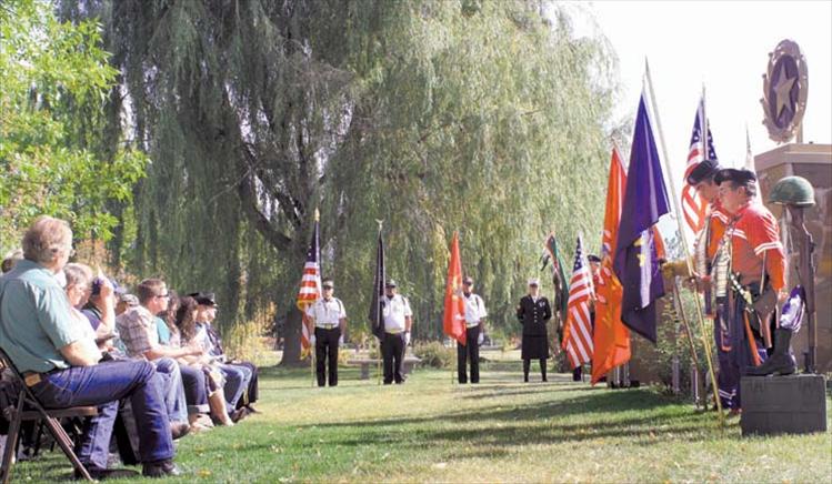 Gold Star mothers and their families (left) listen to a speech as Mission Valley Honor Guard members (Center) and CSKT Veteran Warriors Society members (right) stand guard over the memorial in Ronan’s city park.