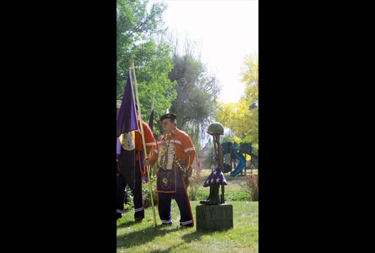 Veteran Warrior Society member Bill Rogers holds the Montana state flag during the ceremony. 