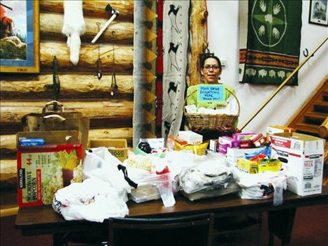 Vernita Charlie,  staff member at the Ninepipes Museum, holds a basket of food donated for the local food pantry.