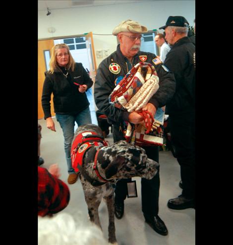 Bill Austin  carries his  Quilt of Valor and the one quilters made for his dog, J, at the presentation on Veterans Day.