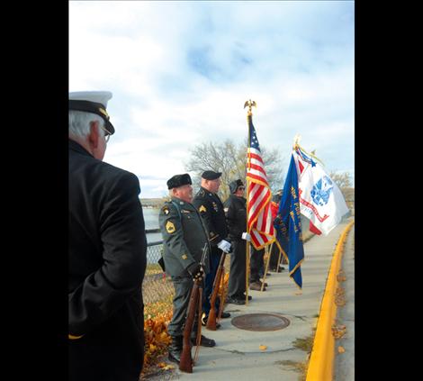 Members of the American Legion, Post 112 in Polson stand at attention along the Armed Forces Memorial Bridge in Polson at 11 a.m. on Nov. 11.