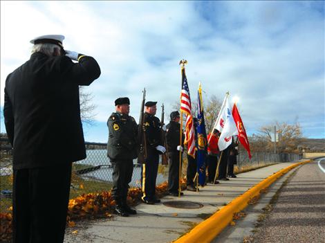 Members of the American Legion, Post 112 in Polson stand at attention along the Armed Forces Memorial Bridge in Polson at 11 a.m. on Nov. 11.