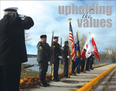 Members of the American Legion, Post 112 in Polson stand at attention along the Armed Forces Memorial Bridge in Polson at 11 a.m. on Nov. 11.