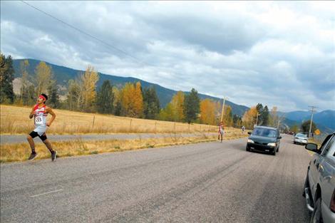 Al Plant dodges mid-day traffic and other runners on the cross-country course during Arlee’s Hatchery Run last week.