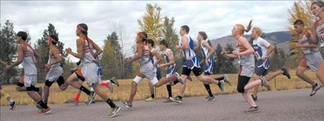 Cross-country runners from St. Ignatius and Arlee spring from the starting line as the race begins