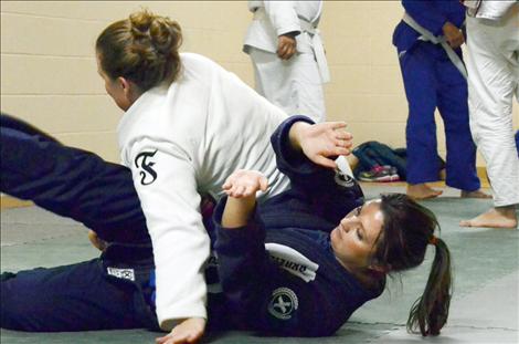 Stacy McElderry practices jiu-jitsu moves with Aspen Incashola.