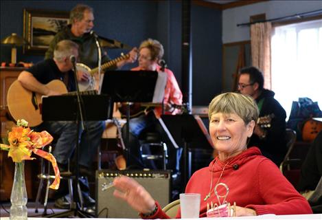 Diane Alderdice keeps the beat as local musicians create festive ambiance with folksy tunes.