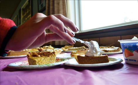 Erika Cook places a dollop of whipped cream on her pie