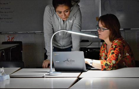 Arlee teacher Anna Baldwin works with a student on a Chromebook.