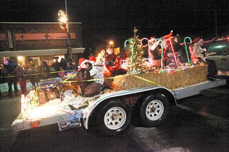 Kids in sunglasses and Santa hats wave from a float in the Polson Parade of Lights on Dec. 5. 
