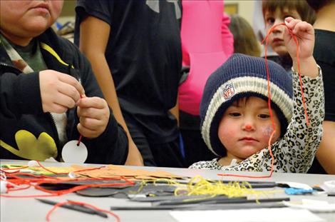 Bella Inmee, 1, selects ribbon for a holiday decoration