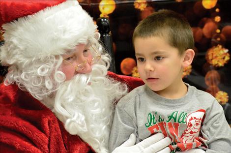 Michael Incashola, 5, shares his Christmas list with Santa at the St. Ignatius carnival.