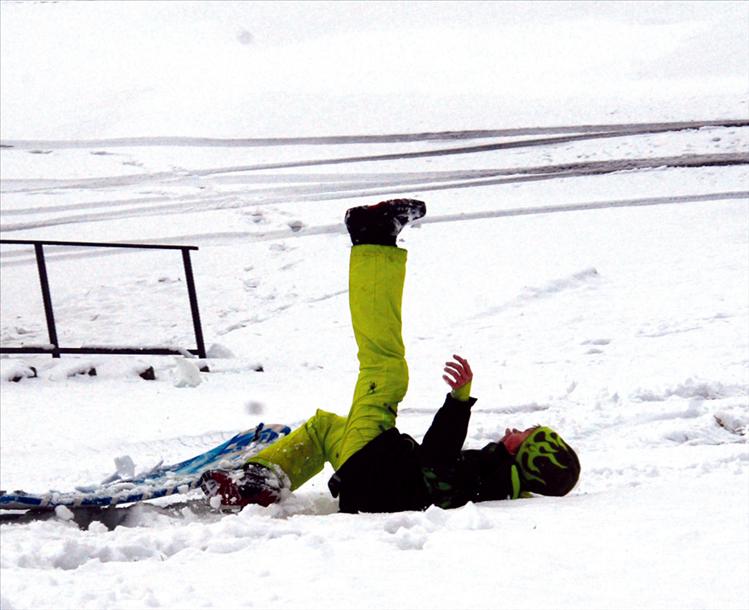 Zevan Walker takes a tumble as he sleds down the steep slope at Riverside Park. 
