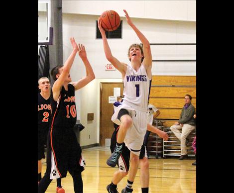 Viking Dalton Delaney fights opponents defense as he jumps for the hoop.