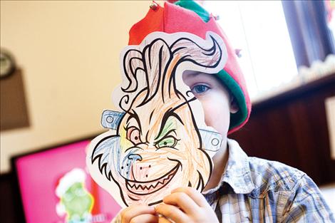 Kaden Anderson creates a Grinch mask. 