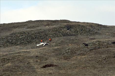 Workers survey wreckage of a plane that crashed south of Polson near back road on Dec. 16. 