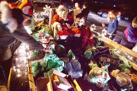 Santa’s presents are loaded into a sleigh by members of the Church of Latter-day Saints after a food and clothing drive. 