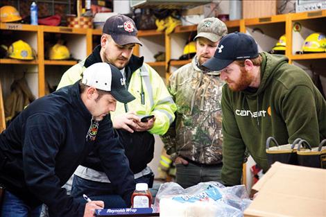 Firefighters prepare a game plan for Christmas present delivery.