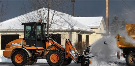 Polson’s new snowblower “loads” snow into the back  of a dump  truck.