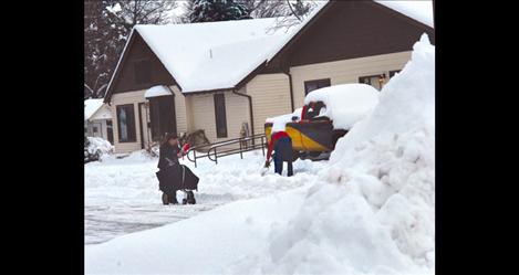 Mail carrier Brandi Elliot fights the snow on her delivery route in Ronan Monday morning as neighbors and businesses dig out from the snowstorm.