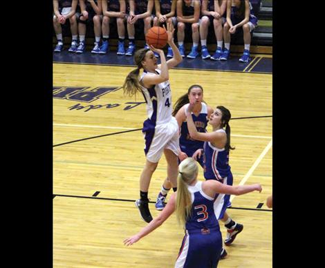 MaKenna Weltz jumps above opponents reach to make shot in Saturday’s game against Columbia Falls.