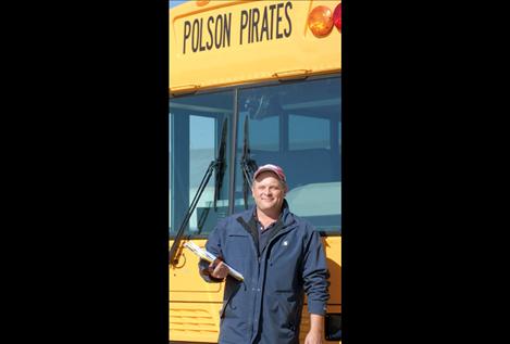 Michael Anderson stands in front of a school bus. He’s the new transportation director for Polson schools.