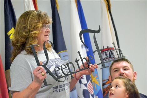 Lisa Jennison-Corbett presents a sign to her son, Tomy, to remind him to keep the faith and “never stop believing that things happen for a reason.”