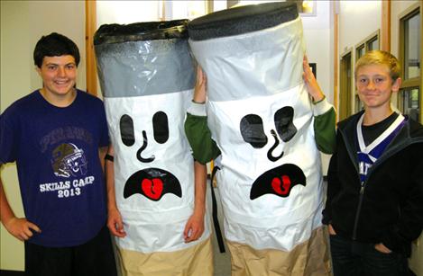 Two Ciggy the Butts have escorts to a classroom for a presentation on tobacco prevention.