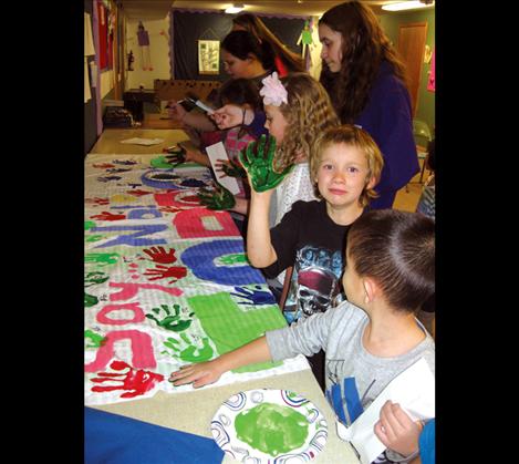 Children at the Boys and Girls Club work with Lake County Health Department staff to create a handprint banner.