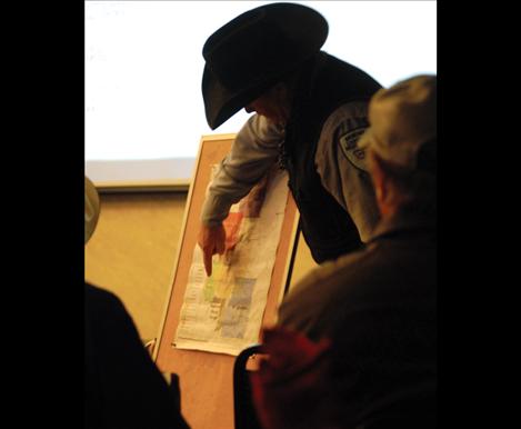 Brand inspector Ernie McCaffree points to a herd district on a map of Montana counties during the WMSA business meeting.