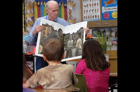 Volunteer reader Ray Salomon holds a big book so first graders can see the pictures as Mary Parsons reads a story about Martin Luther King, Jr.