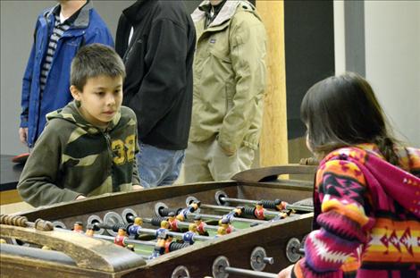 Isaac Gloover, 9, and Alexis Gloover, 7, try out the foosball table in the waiting area at the Cross Collar Academy. 