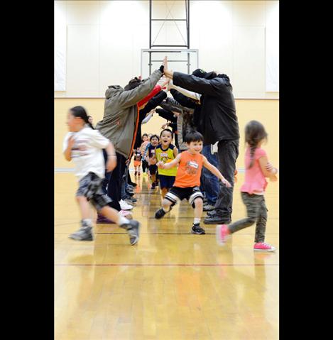 Parents and instructors form a tunnel for the kids to run through.