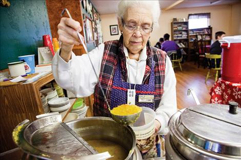 Opal Loveless, an RSVP volunteer, scoops soup in the warm kitchen of the Wander Inn, an outreach of Journey Be, to feed the community.