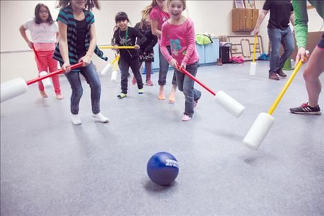 Nicole Tavenner/Valley Journal Kids stretch after fun games at the Ronan Indian Senior Citizen Center, above, and are given trail mix for snack time, below.