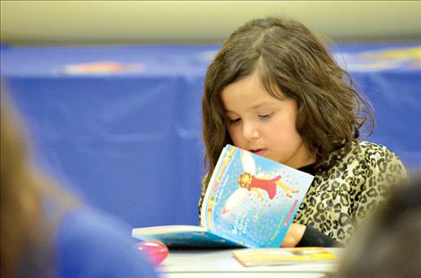 Karen Peterson/Valley Journal Caramia Never Miss A Shot, 7, finds a good book.