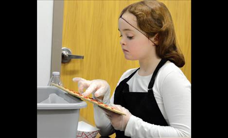 Allyson Umphrey, 10, plays bingo while she sells hot dogs. 