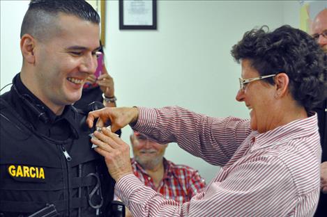 Ronan Police officer James Garcia has his new badge pinned on by City Clerk Kaylene Melton.